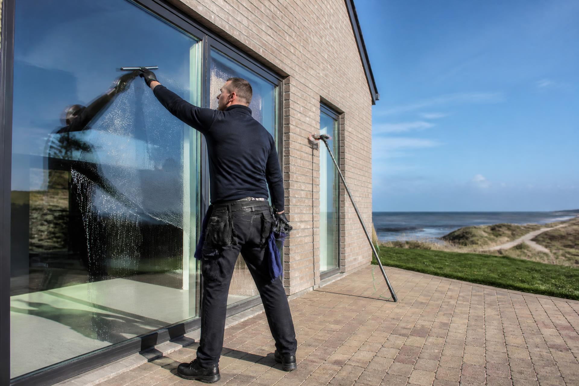 Vinduespolerer pudser store glaspartier på hus i Vestjylland